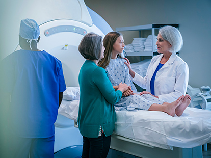 A doctor comforts a female patient about to have a CAT scan.