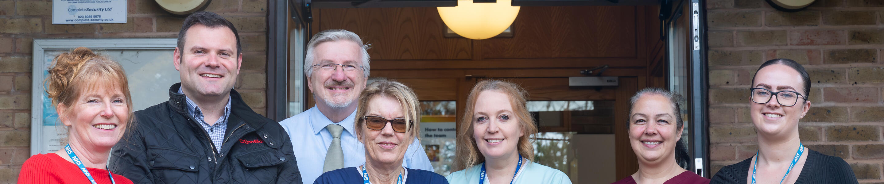 group of healthcare providers standing in front of building