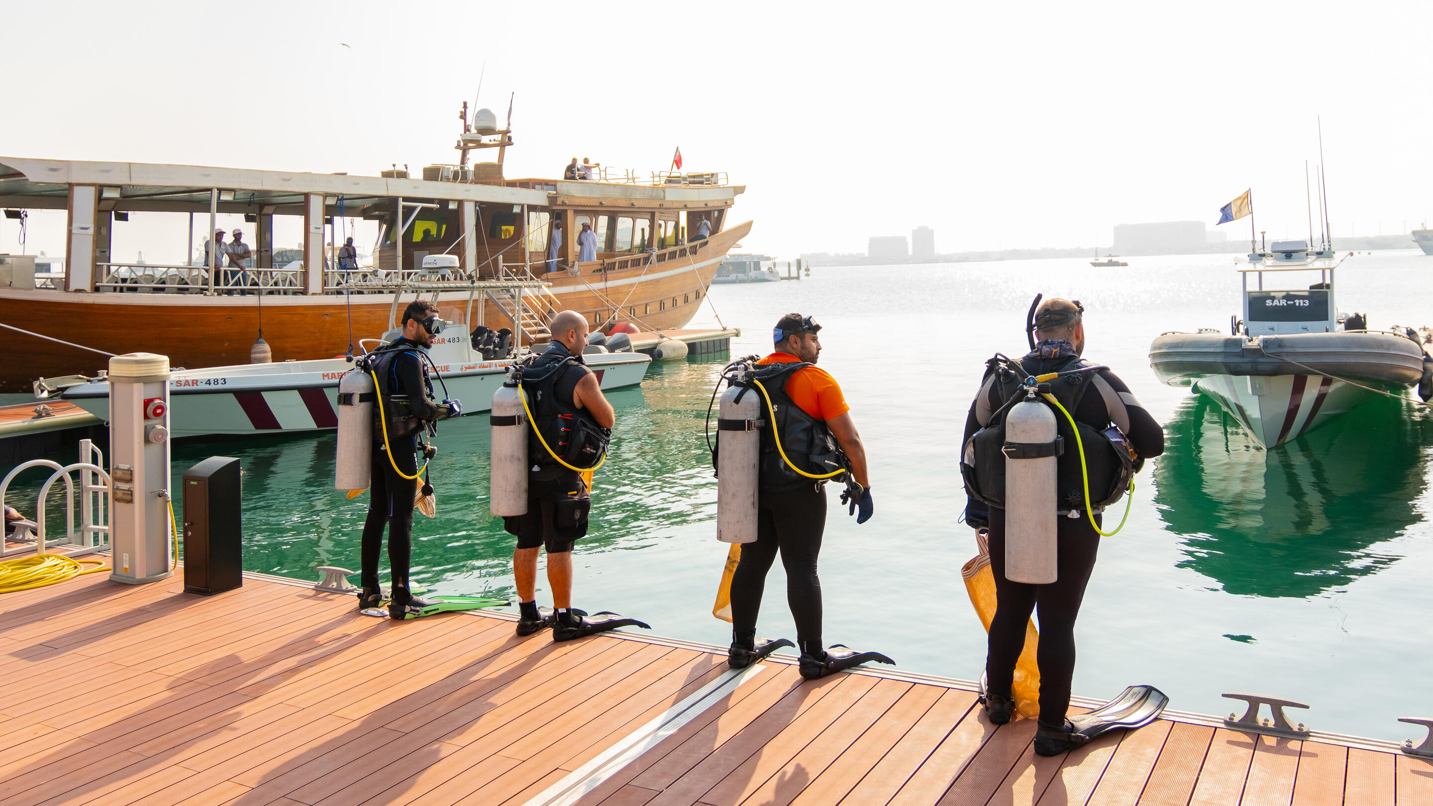 Divers before they entered the waters of Old Doha Port to  begin removing harmful debris.