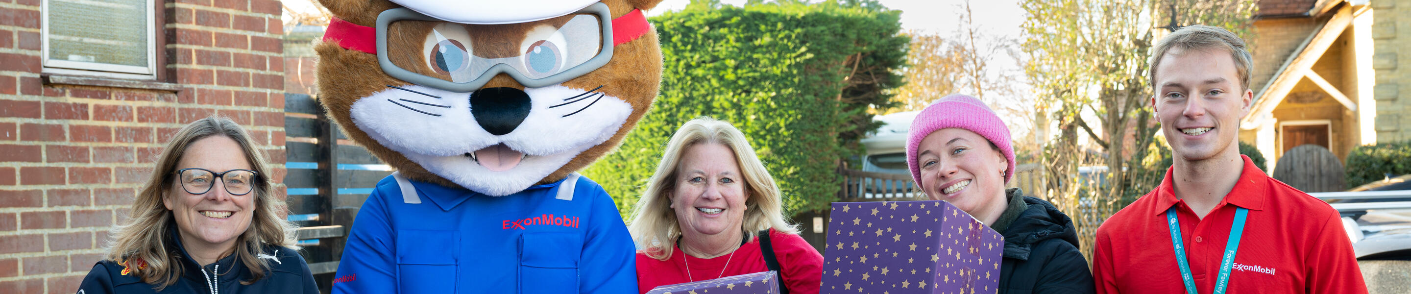 ExxonMobil Fawley mascot with employees holding gifts for annual hamper donation