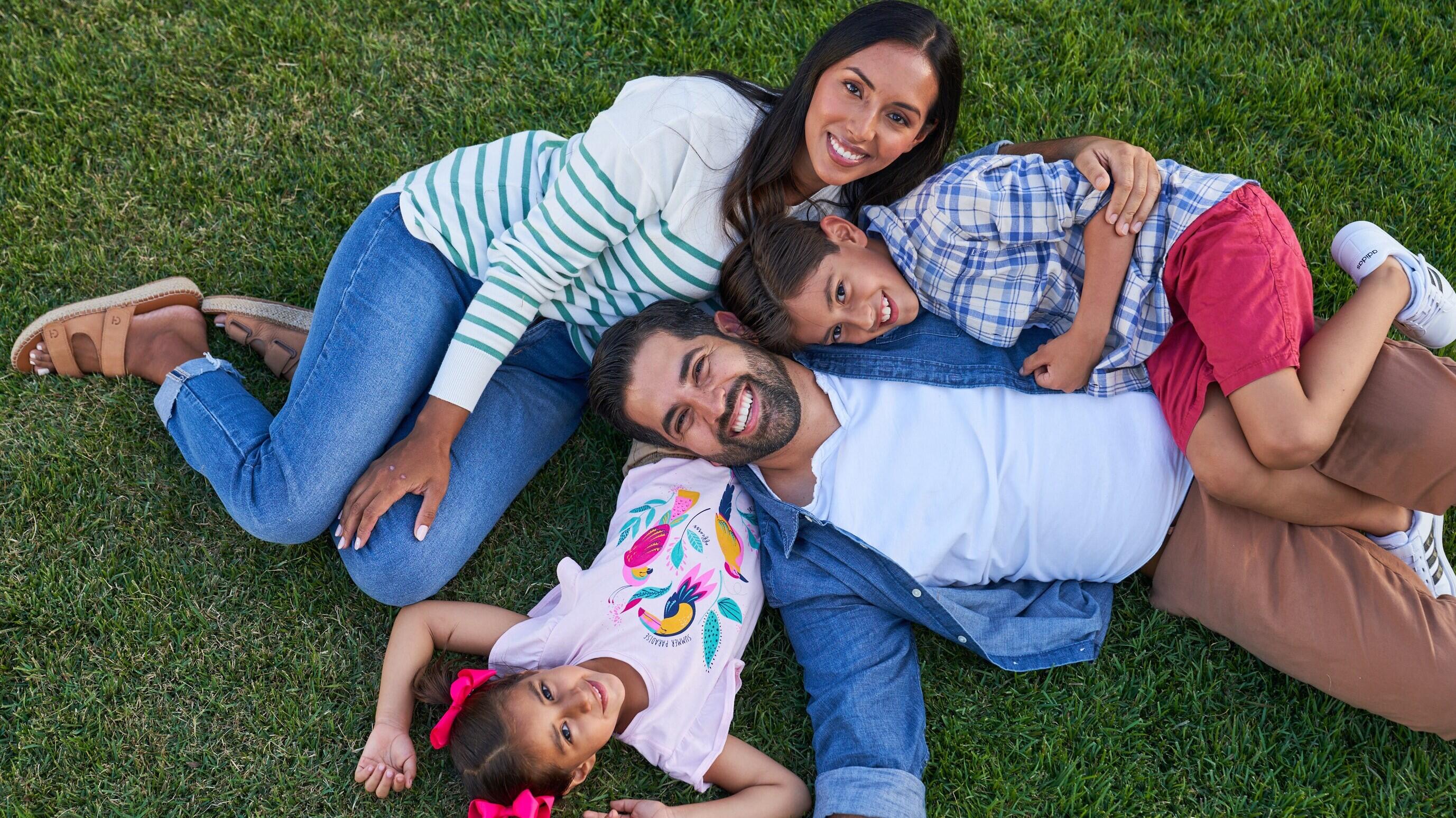 family relaxing together on a grassy lawn