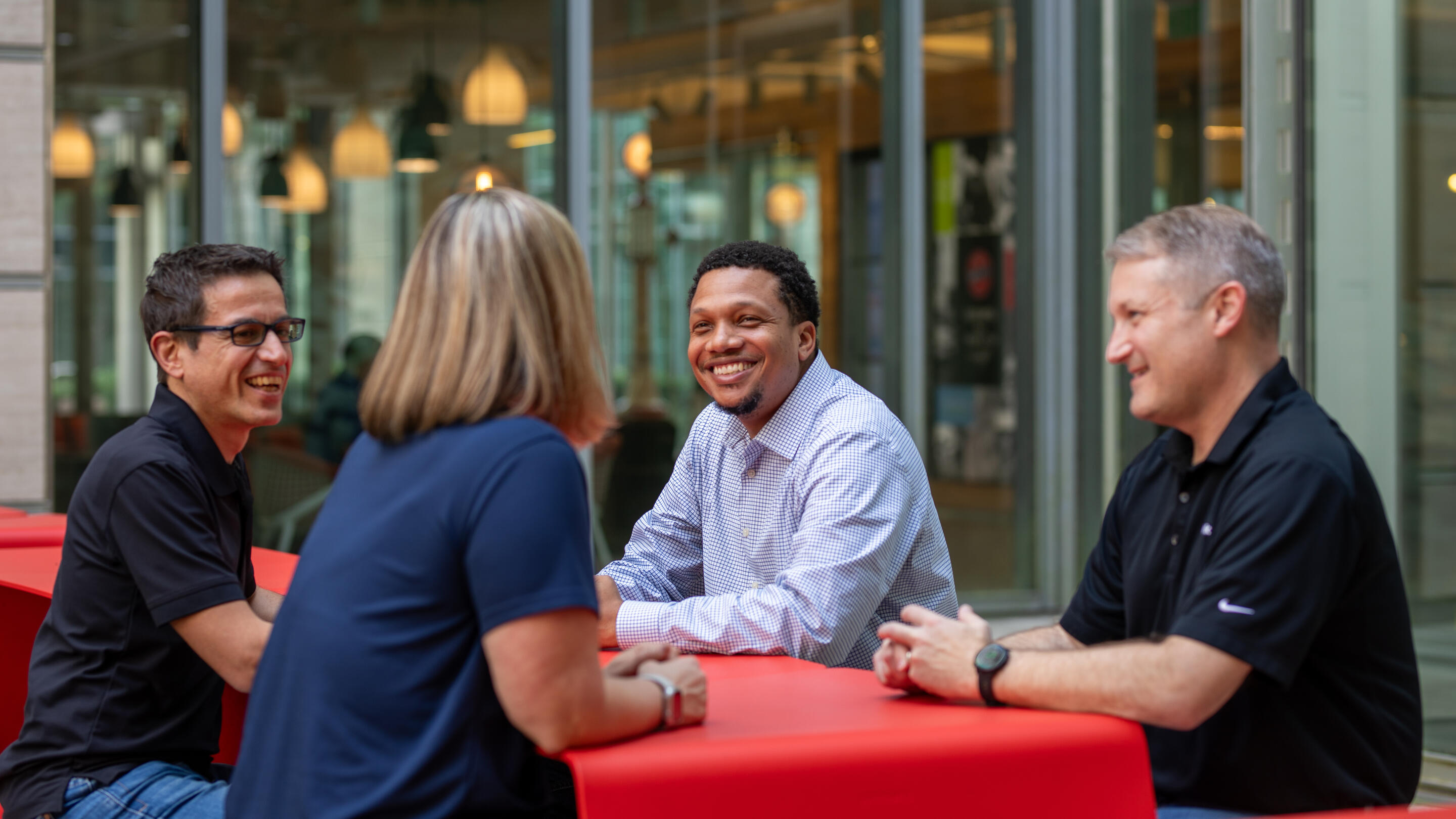 ExxonMobil employees seated around a table, talking