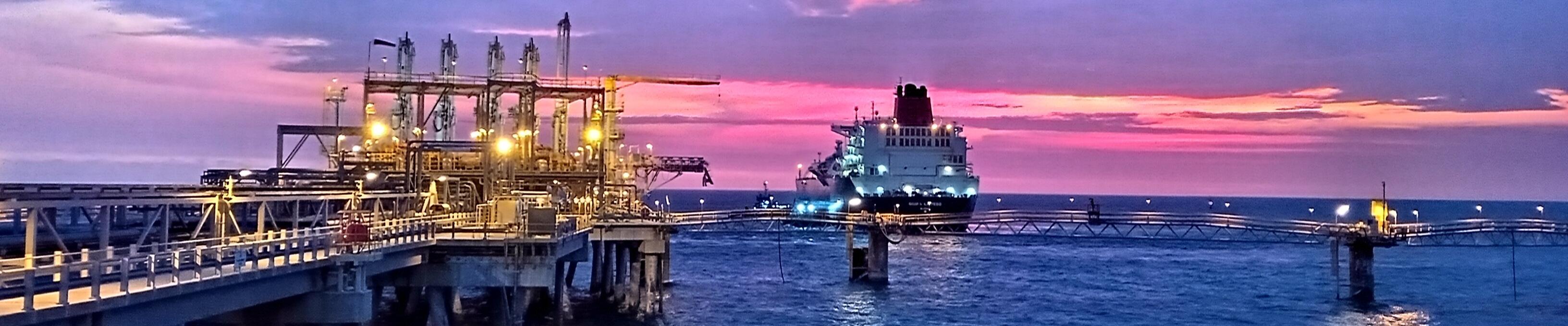 port with ship approaching at sunset