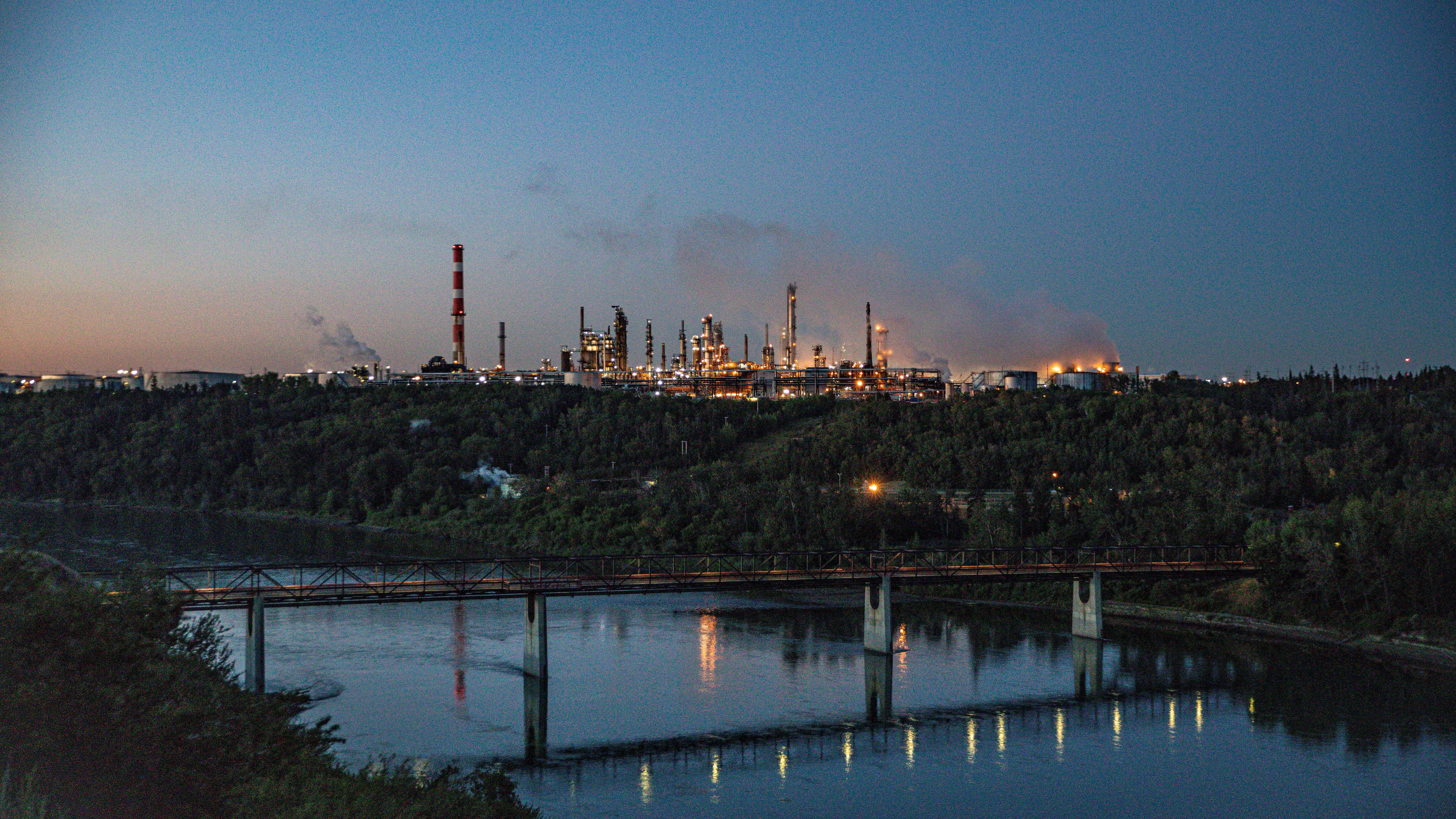 An industrial facility situated on a hill surrounded by dense forest.