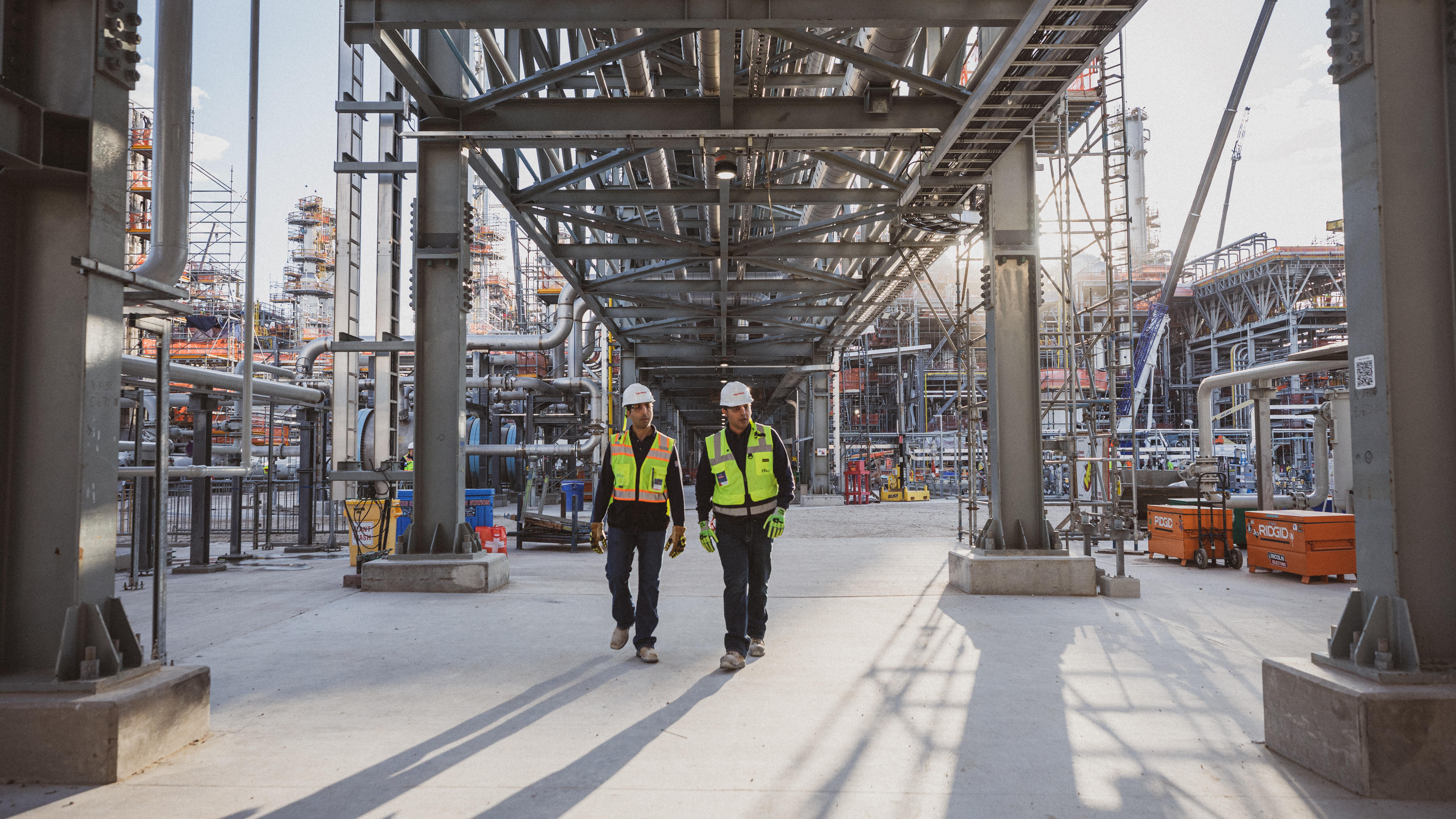 workers in protective gear walking through Baytown petrochemical facility