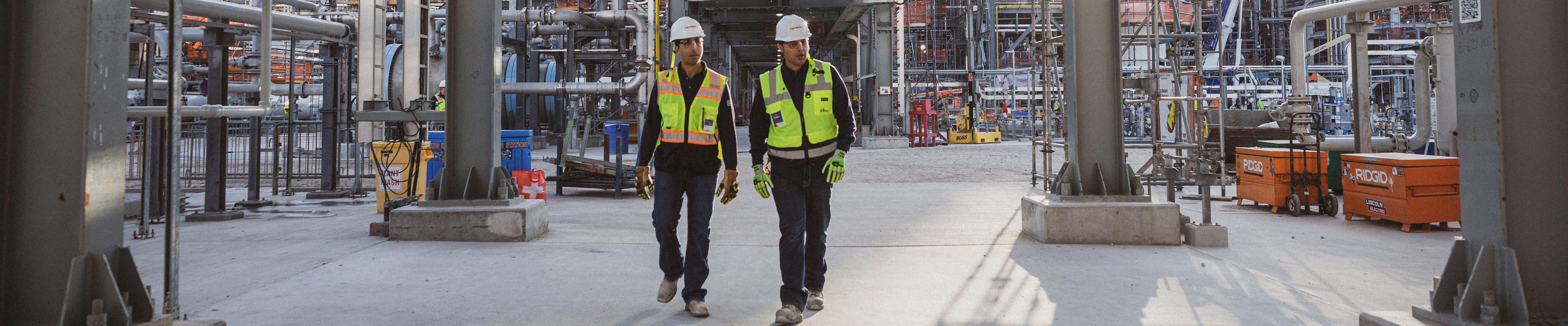 workers in protective gear walking through Baytown petrochemical facility