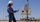 A person wearing a white hard hat, blue long-sleeve shirt, and jeans is standing outdoors at XTO operations in the Permian Basin.