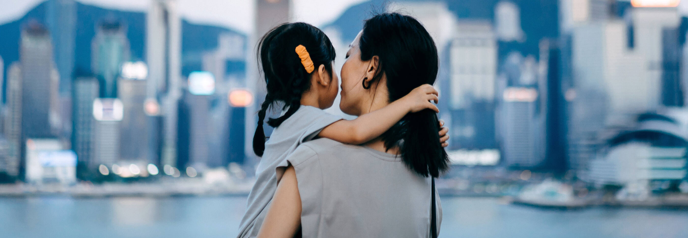 Woman holding child looking at the city.