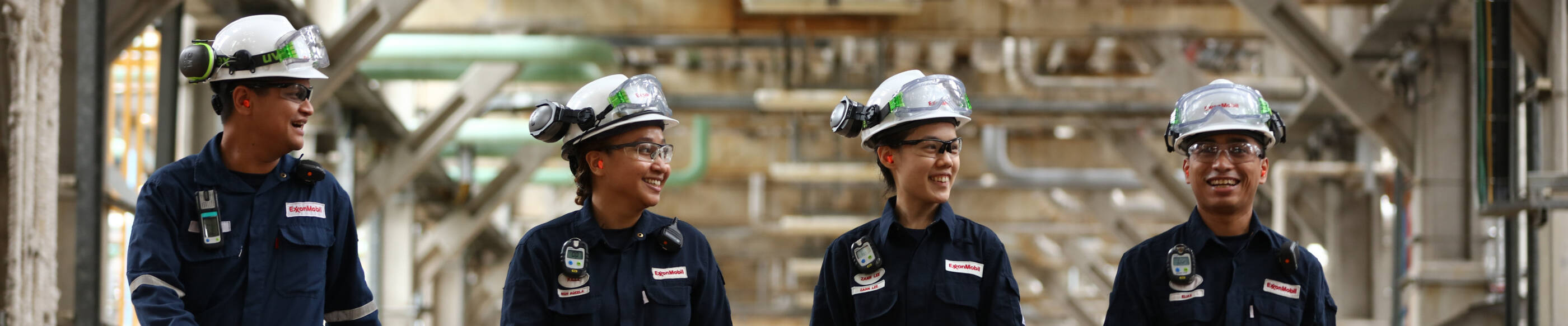 diverse group of refinery complex employees walking through the complex