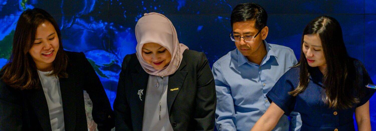 Four coworkers looking at paperwork on a table