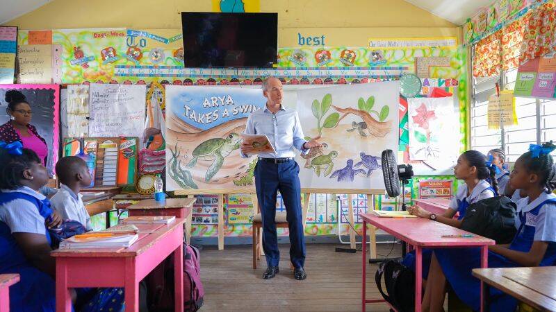 Lead country manager of Guyana, Alistair Routledge, sharing Arya takes a swim with a class of excited students.