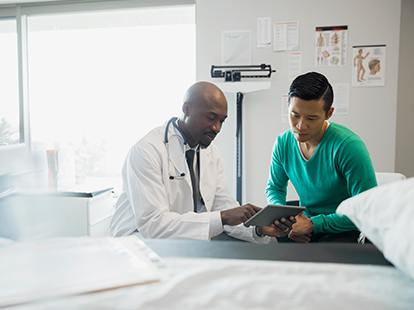 A doctor and patient reviewing the patient's medical case in an exam room.