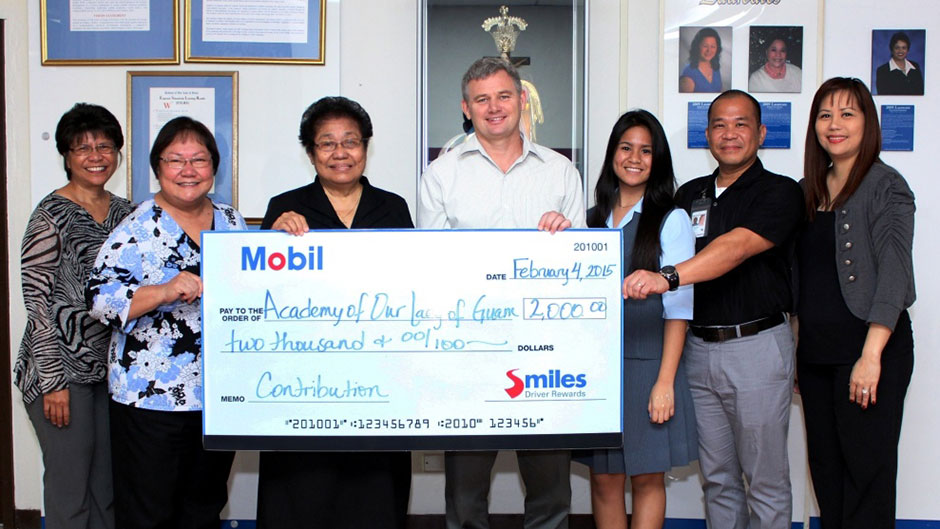 Holding a donation check for the Aademy of our lady of Guam