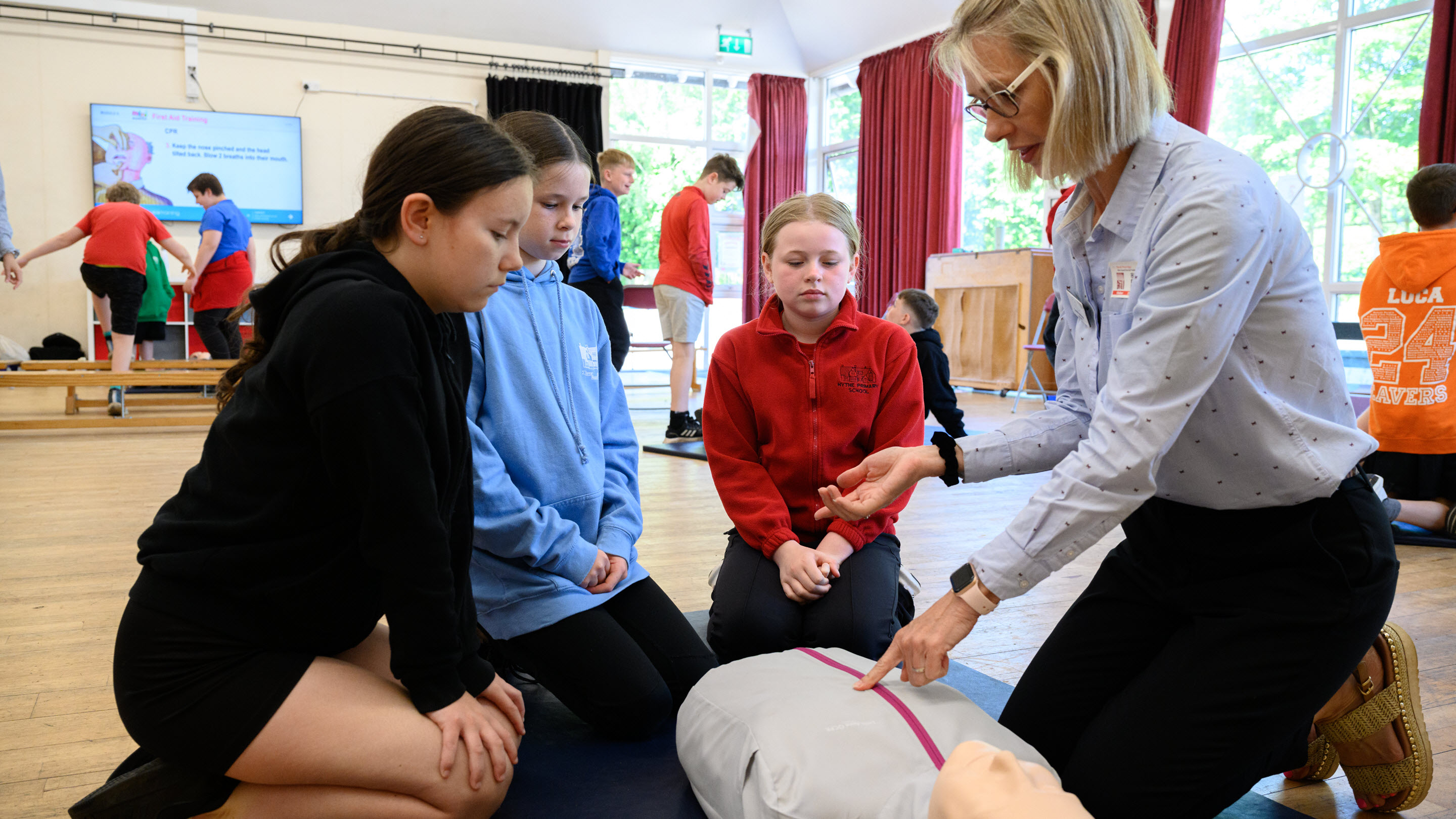 small group of young girls learning first aid