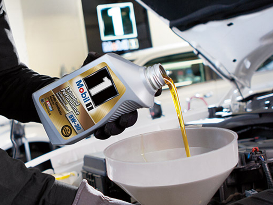 Mobil 1 motor oil pouring into automobile