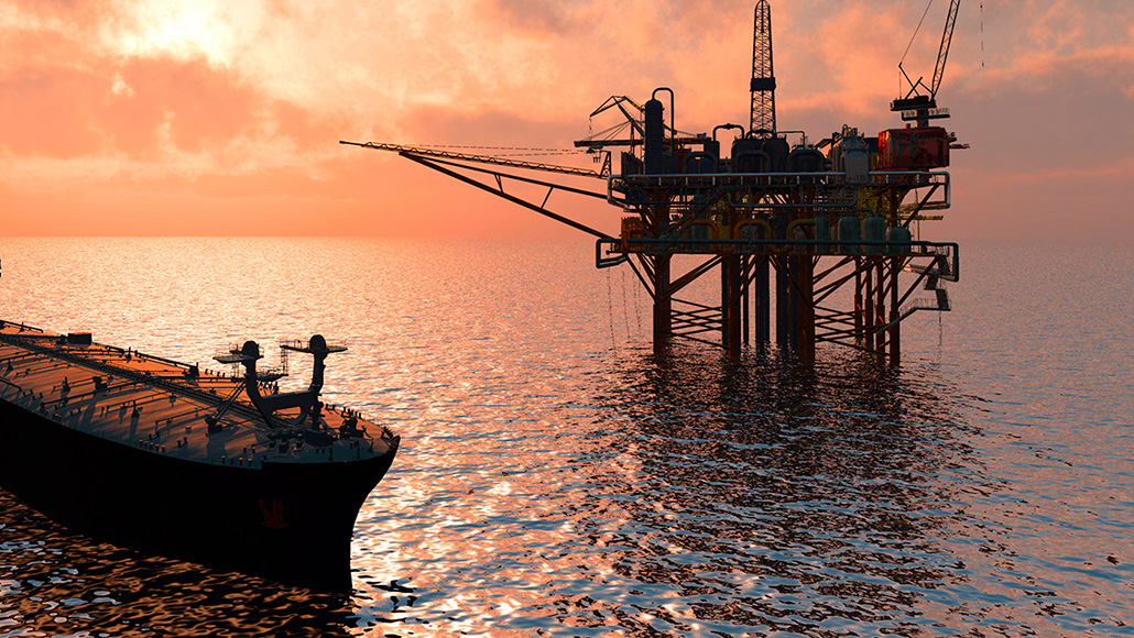 oil rig at dusk out at sea 