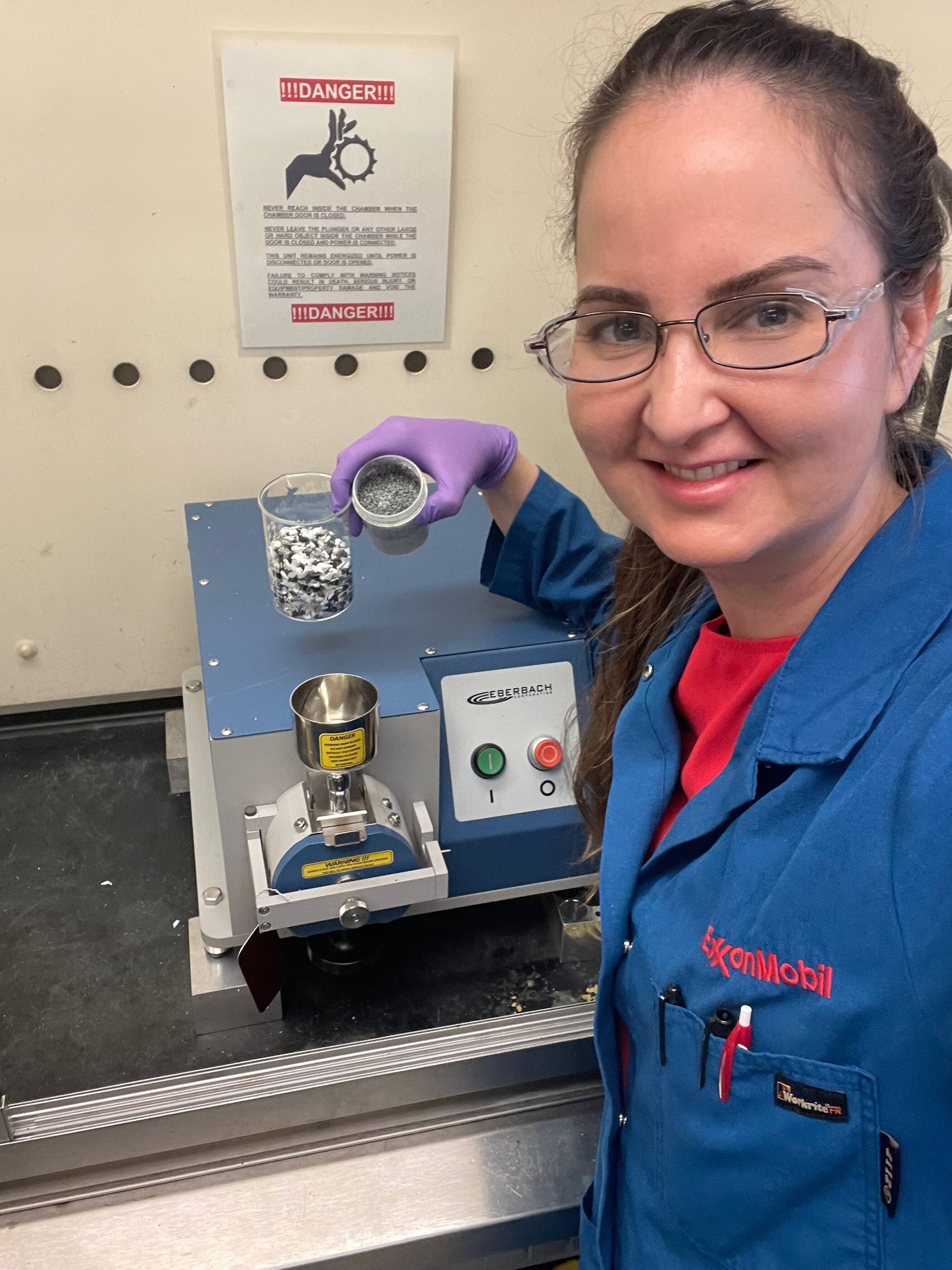 Stephanie is pictured in the lab with a mini-grinder used to conduct chemical analysis of plastic waste.