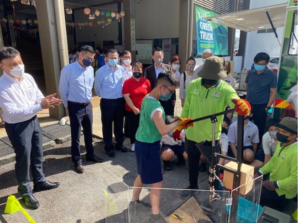 Image Members of the Green Truck initiative teaching students about plastics recycling.