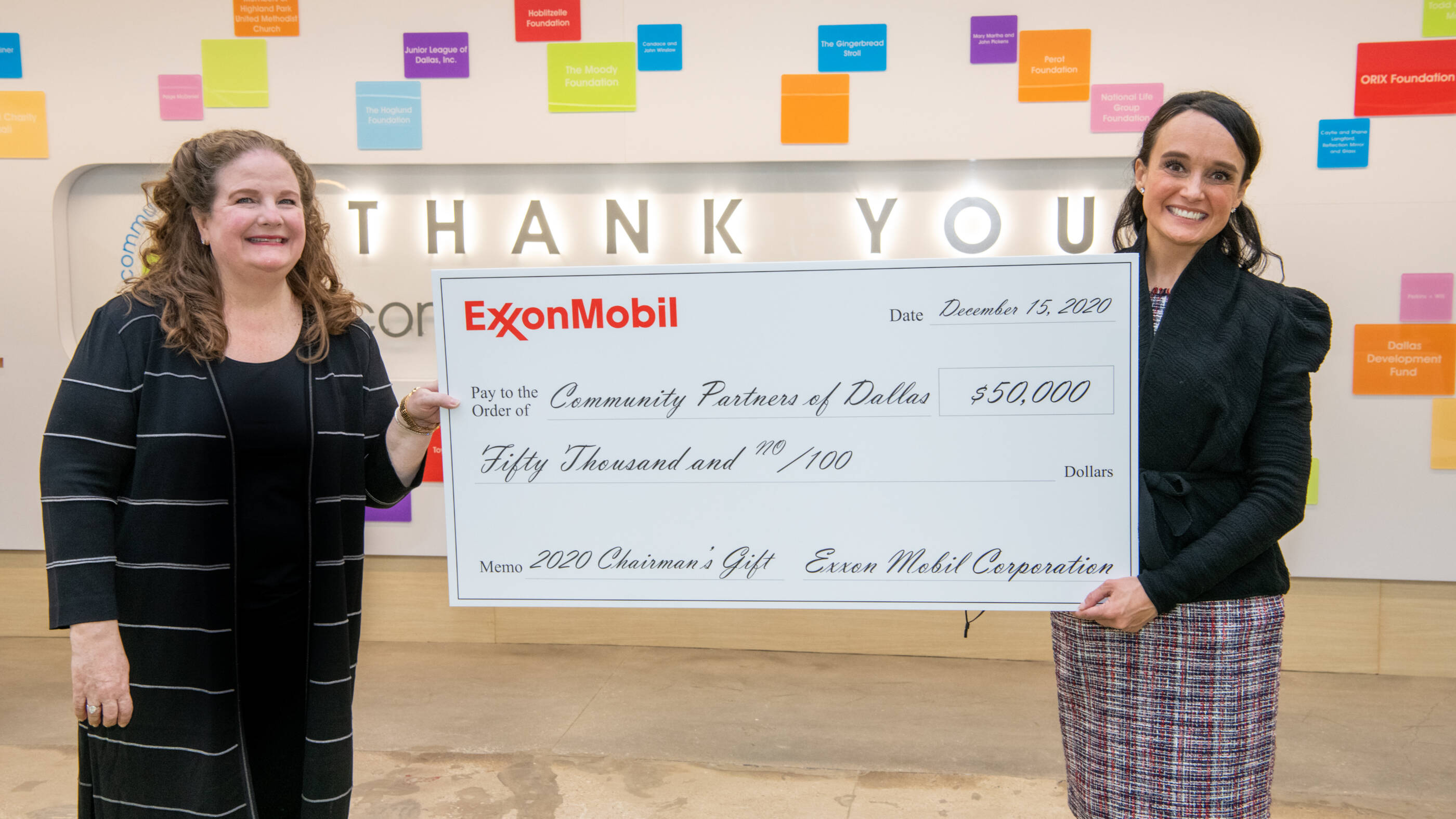 Paige McDaniel, president and chief executive officer of Community Partners of Dallas, and Joanna Clarke, vice president of development and communications of Community Partners of Dallas, receive $50,000 from ExxonMobil.